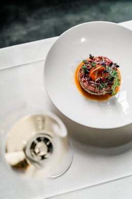 Handgeschnittenes Tartar vom Rindsfleisch mit mariniertem Sushi-Reis Wasserspinat Kräutersalat mit Weisswein