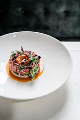 Handgeschnittenes Tartar vom Rindsfleisch mit mariniertem Sushi-Reis Wasserspinat Kräutersalat